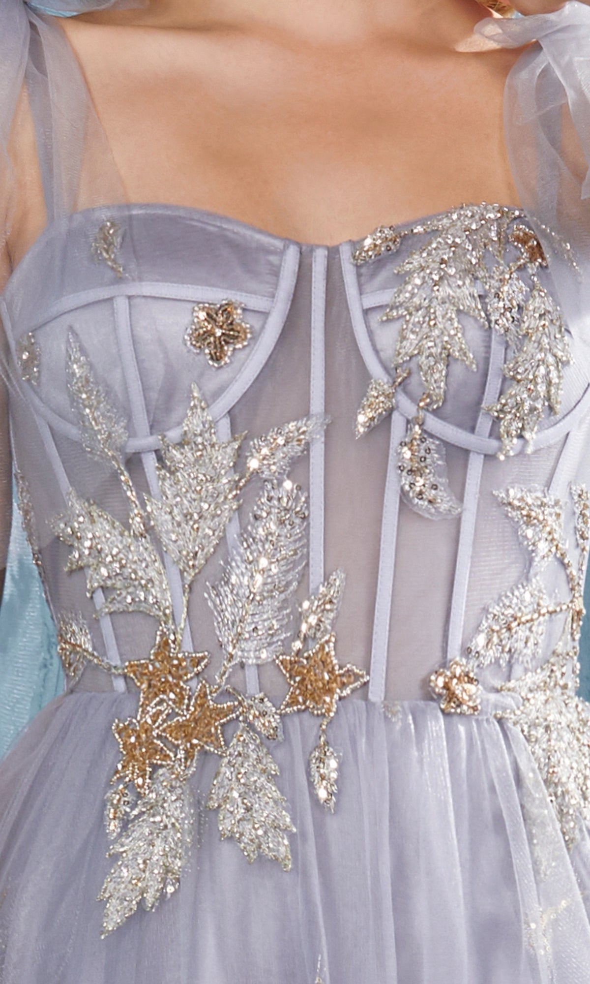 Close-up of the Shoulder-Bow Long Corset Prom Ball Gown A0824 in lavender sheer fabric, featuring a corset bodice decorated with silver and gold sequin leaf and star embellishments.